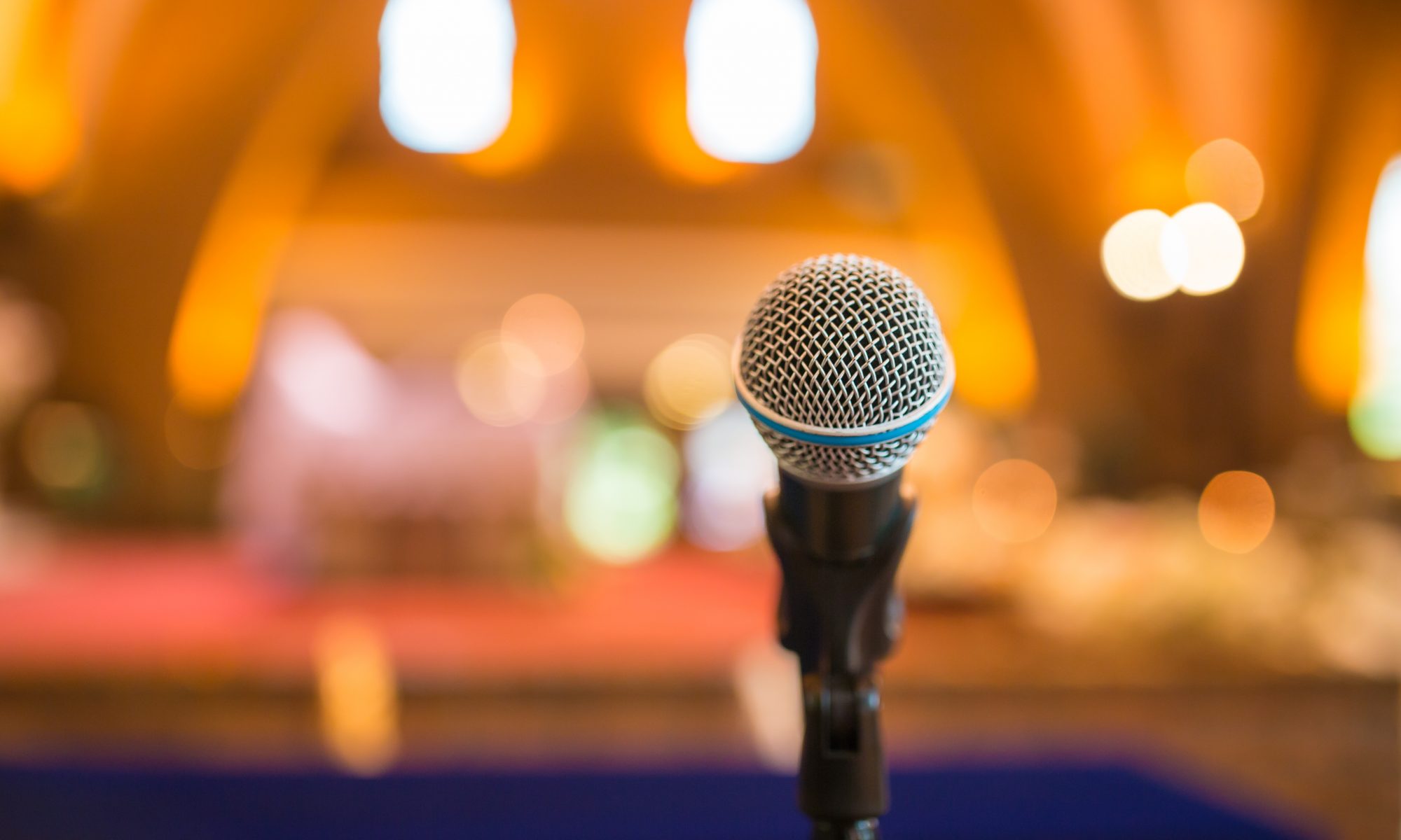 Do you need a Speaker - ask the agency Premium Speakers for support and booking. Picture: Microphone in concert hall or conference room with defocused background, Speaker