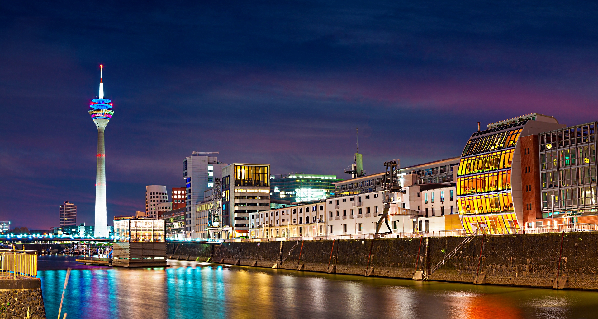 Colorful night scene of Rhein river at night in Dusseldorf. Rheinturm tower in the soft night light, Nordrhein-Westfalen, Germany, Europe.