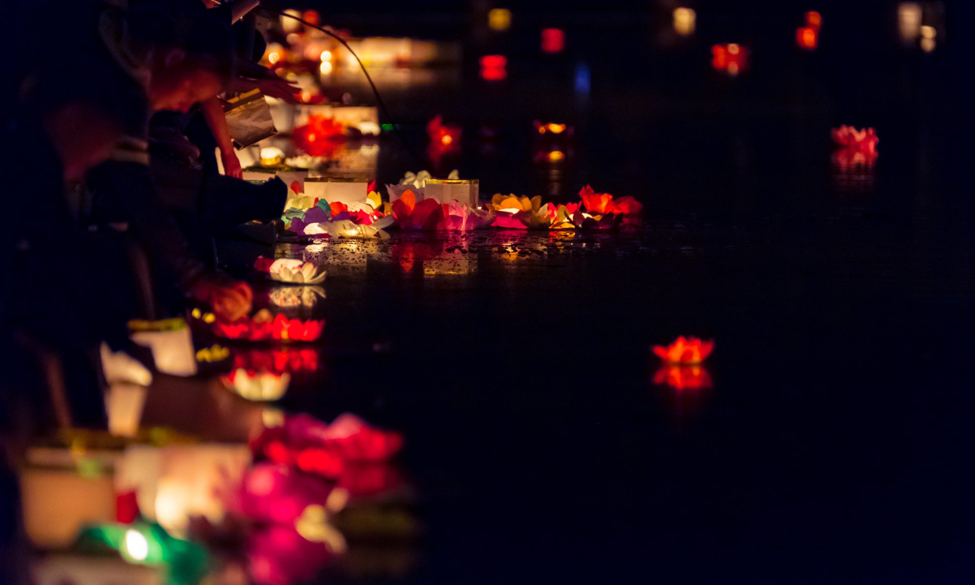 Floating paper lanterns on the water at night